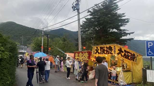 花火会場の屋台が並ぶ通りを歩く人々